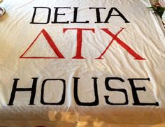 the delta atx house blanket is laying on top of a bed with red and black letters