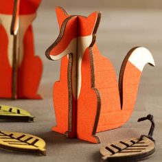 an origami fox sitting on the ground next to other pieces of paper