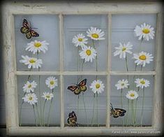 butterflies and daisies are painted on the glass in this window pane, which is decorated with white daisies and yellow centers