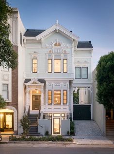 a large white house with many windows on it's sides and stairs leading up to the front door