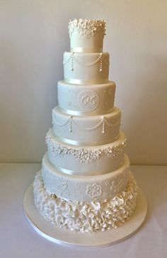 a wedding cake with white frosting and flowers on the top tier is displayed in front of a white background