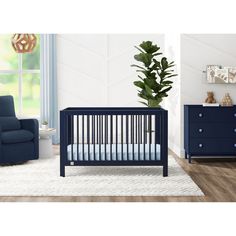 a baby's room with a blue crib and white rug