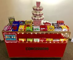 a popcorn machine with candy and snacks on it's display table in an office