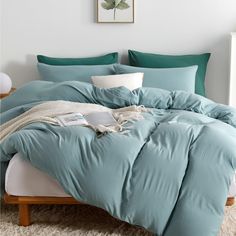 a bed with blue sheets and pillows in a room