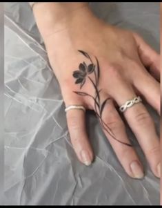 a woman's hand with a flower tattoo on it