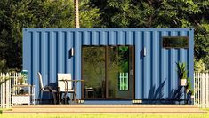 a blue shipping container sitting on top of a lush green field