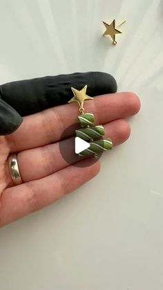 a person's hand with two gold stars on it, and an ornament in the shape of a christmas tree