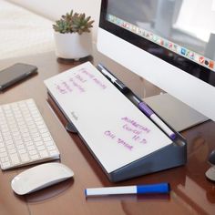 a notepad with writing on it sitting next to a keyboard and mouse, along with a computer monitor