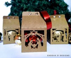 three brown boxes with red bows and decorations in front of a christmas ornament