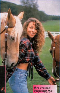 a woman standing next to a brown horse