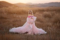 a woman in a pink dress standing in a field