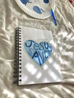 a paper plate with the words jesus saves written on it next to a spiral notebook