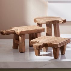 three wooden stools sitting on top of a white counter