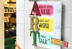 the letters are made out of colored paper and placed on a white wall in a store