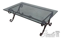 a glass coffee table with wrought iron legs