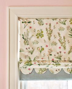 a window with a flowered valance hanging from it's side next to a window sill