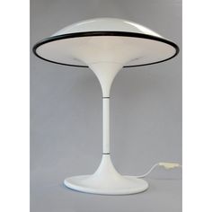 a white table lamp sitting on top of a gray floor