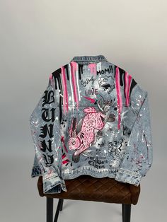 a jacket with graffiti on it sitting on top of a chair