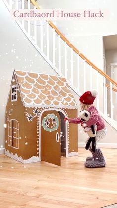 a teddy bear in a red hat is holding a door to a gingerbread house