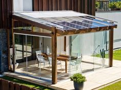 a house with a glass roof and wooden decking on the grass area next to it