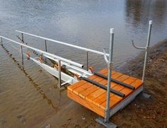 a wooden dock sitting in the middle of a flooded river next to a boat ramp