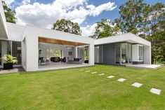 a modern house in the middle of a lush green field