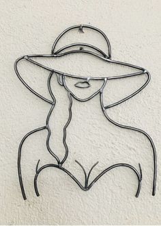 a wire sculpture with a woman wearing a hat and glasses on it's face