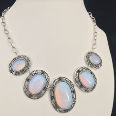 Moonstone Oval Cabochons Silvertone Choker Necklace Lovely oval cabochons set in silver tone metal oval base framed with swirls and floral motifs.  For size and length/drop information refer to image with ruler. Images forms part of the description so please look carefully and ask any questions.  Happy to respond to all queries. Fast and fully trackable shipping. Silver Oval Cabochon Jewelry With Stones, Silver Jewelry With Oval Cabochon Stones, Ornate Silver Necklace With Cabochon, Ornate Silver Cabochon Necklace, Silver Oval Gemstone Cabochons, Oval Cabochon Costume Jewelry Necklace, Silver Oval Bohemian Necklaces, Silver Oval Costume Jewelry Necklace, Silver Oval Cabochon Jewelry With Natural Stones