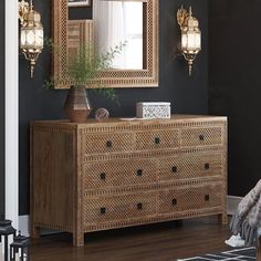 a wooden dresser sitting next to a mirror on top of a wall in a room