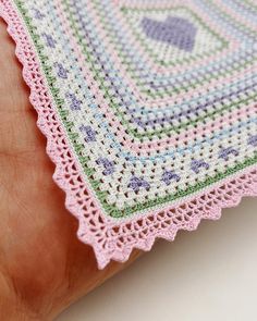 a hand is holding a crocheted doily