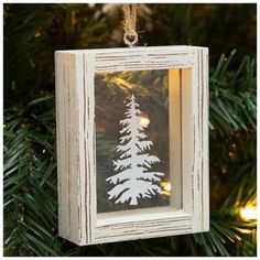 a white christmas ornament hanging from a tree