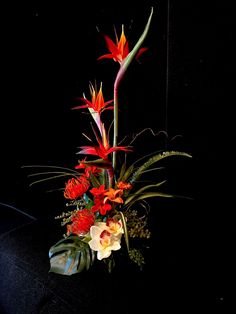 an arrangement of flowers is displayed in the dark