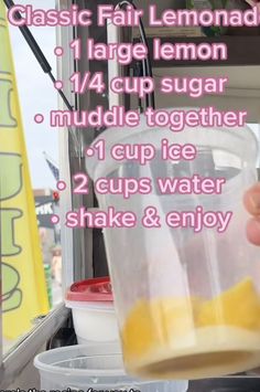 a hand holding a cup filled with lemonade next to a container full of ice cream