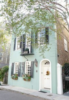 a blue house with black shutters and windows