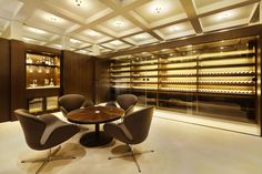 a dining room with chairs and a table in the center, lighted by recessed lights