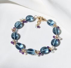 London Blue Quartz Bracelet with Amethyst, Pearl and Topaz, 14K Gold Filled, Blue Statement Bracelet, Unique Handmade Gift for Her D E T A I L S * Featuring blue quartz 9x 11 mm faceted oval beads and amethyst, blue topaz and pearl rondels * Bracelet length is adjustable from 17.5 cm to 19.5 cm (17.5 cm + 2 cm extender) with 14k gold filled metal components P A C K A G I N G - This bracelet will come with a gift box, gift wrapping option is available at checkout with additional cost. S H I P P I Blue Faceted Amethyst Jewelry, Faceted Blue Amethyst Jewelry, Fine Jewelry In Blue Amethyst, Fine Jewelry Blue Amethyst Jewelry, Blue Amethyst Gemstone Bracelet, Oval Beads, Handmade Gifts For Her, Jewelry Picture, Gemstone Jewelry Handmade