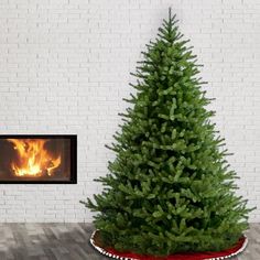 a small christmas tree sitting in front of a fireplace