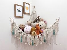 there is a hammock filled with stuffed animals on the wall next to pictures