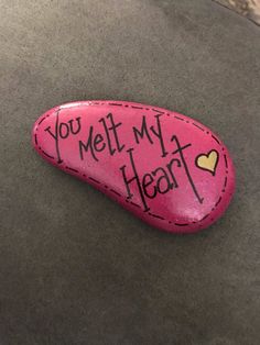 a pink rock with the words you melt my heart written on it and a yellow heart