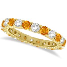 an orange and white diamond ring in yellow gold with diamonds on the sides, set against a