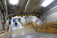 an overhead view of people walking up and down the stairs in a subway station,