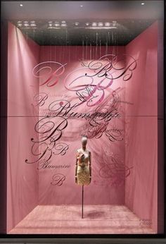 a window display with pink walls and chandelier hanging from it's sides