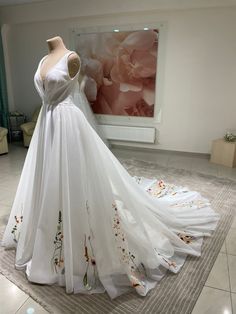 a white wedding dress on display in a room