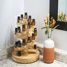 a wooden stand with bottles on it next to a vase filled with flowers and an orange flower