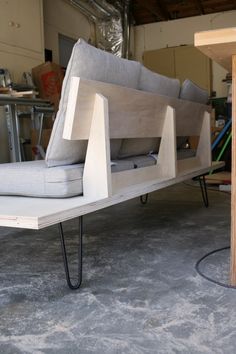 a couch sitting on top of a wooden table in a room with other furniture and tools