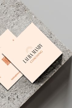 two business cards sitting on top of a stone table next to each other with the words library