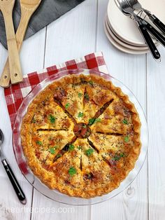 a pizza sitting on top of a table next to silverware and utensils