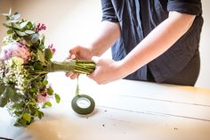 a person is arranging flowers on a table