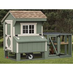 a green chicken coop with a brown roof and two chickens in it's cage