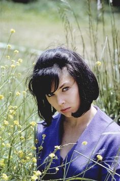 a woman is sitting in the tall grass